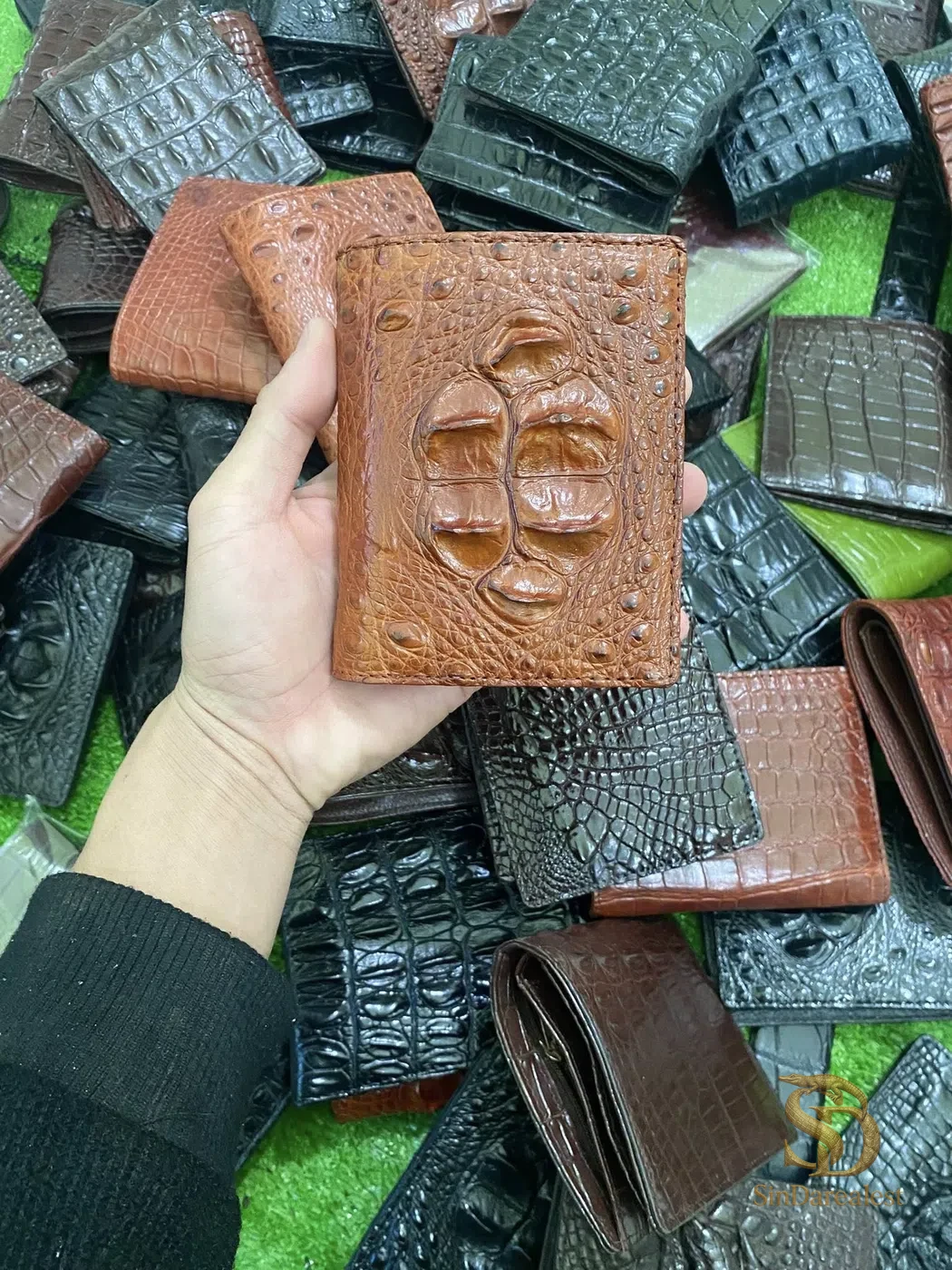 Ví da cá sấu bụng được cầm trên tay, thể hiện cấu trúc vân da tự nhiên